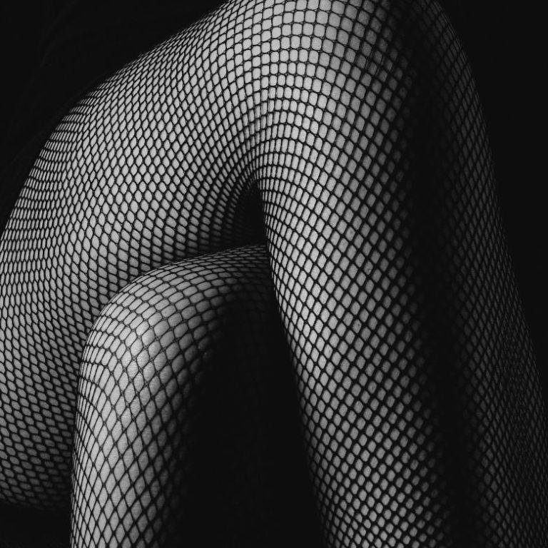 woman in fishnets with legs crossed